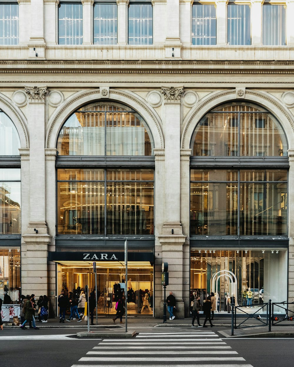 a group of people crossing a street in front of a building