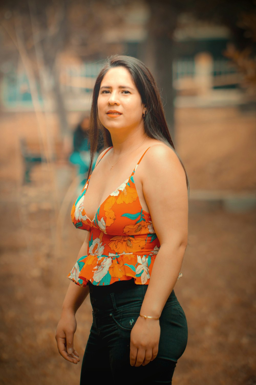 a woman in a floral top poses for a picture