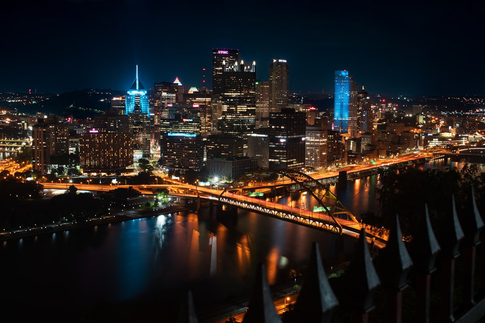 a view of a city at night with a bridge in the foreground