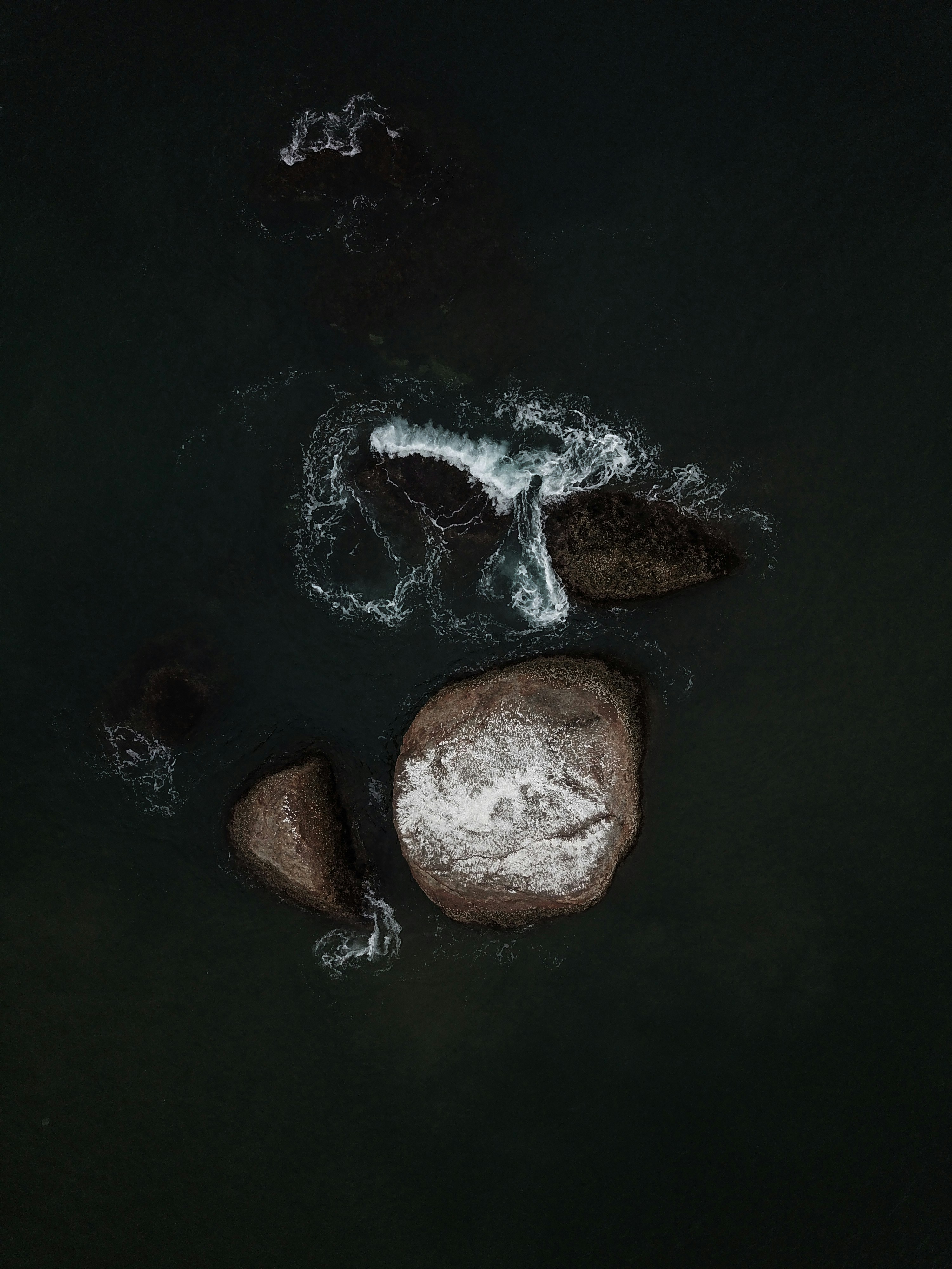 a couple of rocks in the middle of a body of water