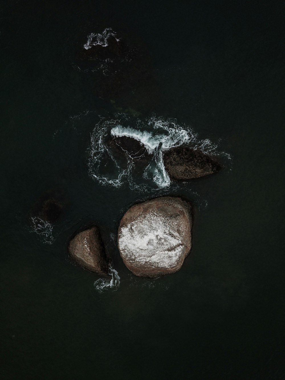 a couple of rocks in the middle of a body of water