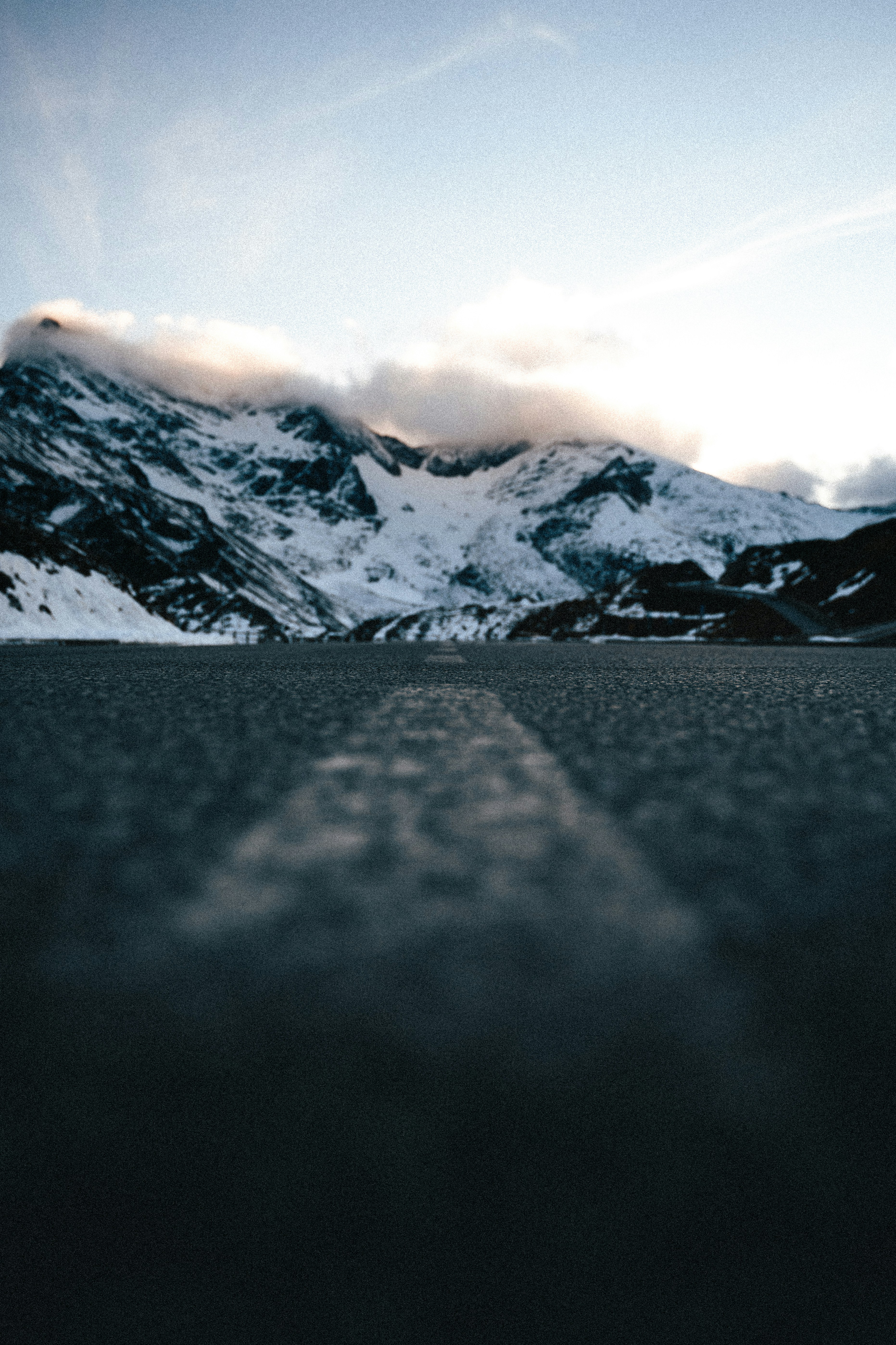 a skateboarder is riding down the street in front of a mountain
