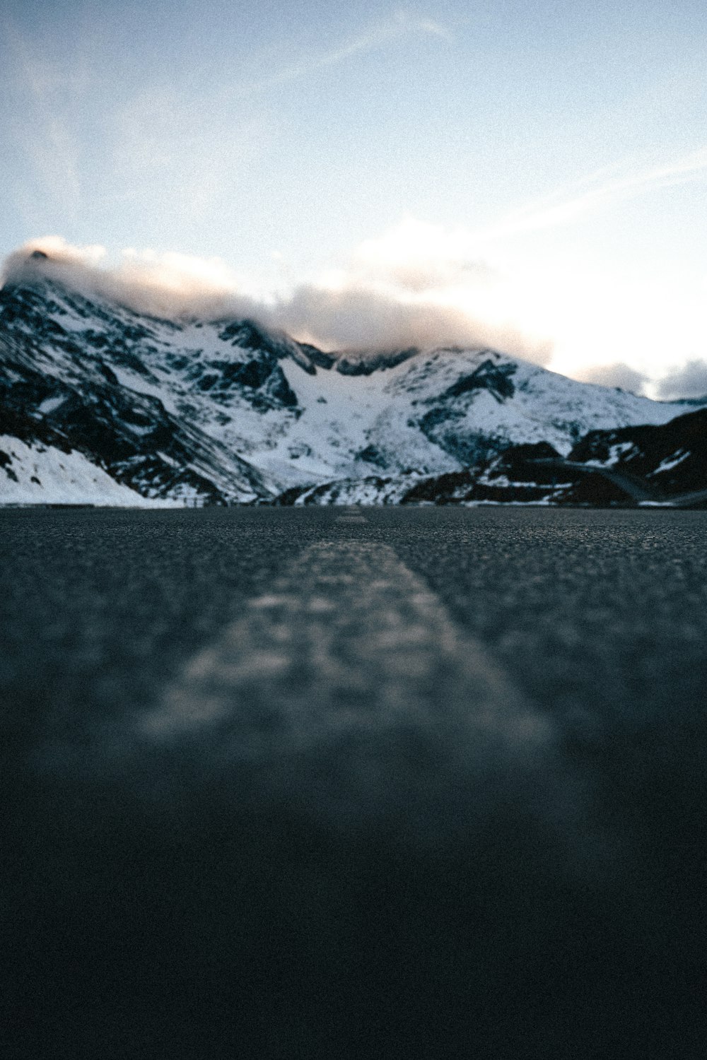 um skatista está andando pela rua em frente a uma montanha