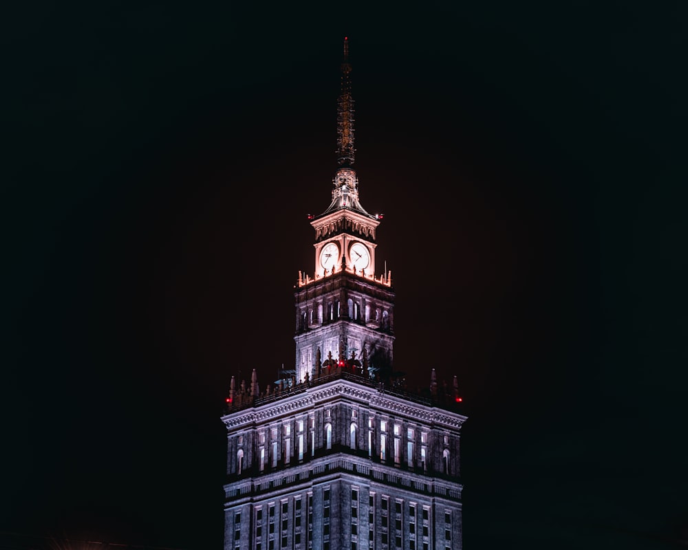 a tall clock tower lit up at night