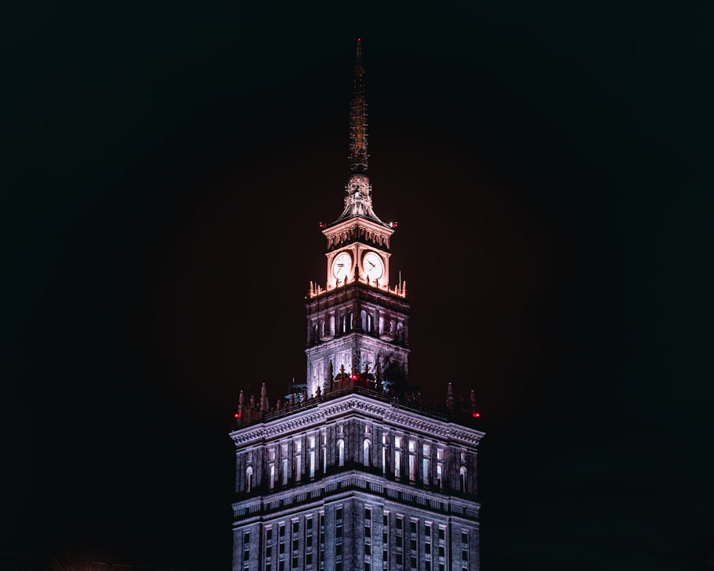 un'alta torre dell'orologio illuminata di notte