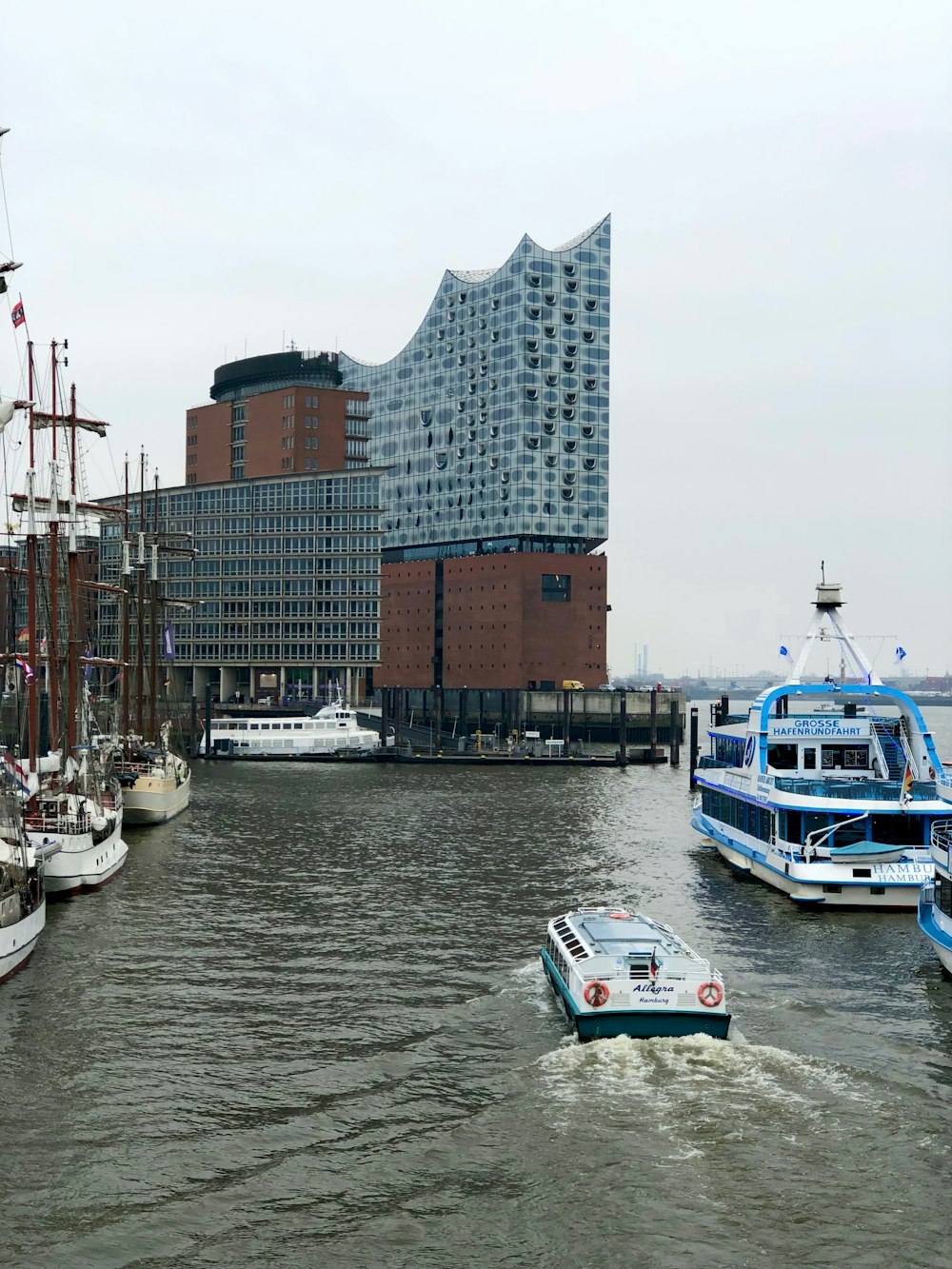 a boat traveling down a river next to tall buildings