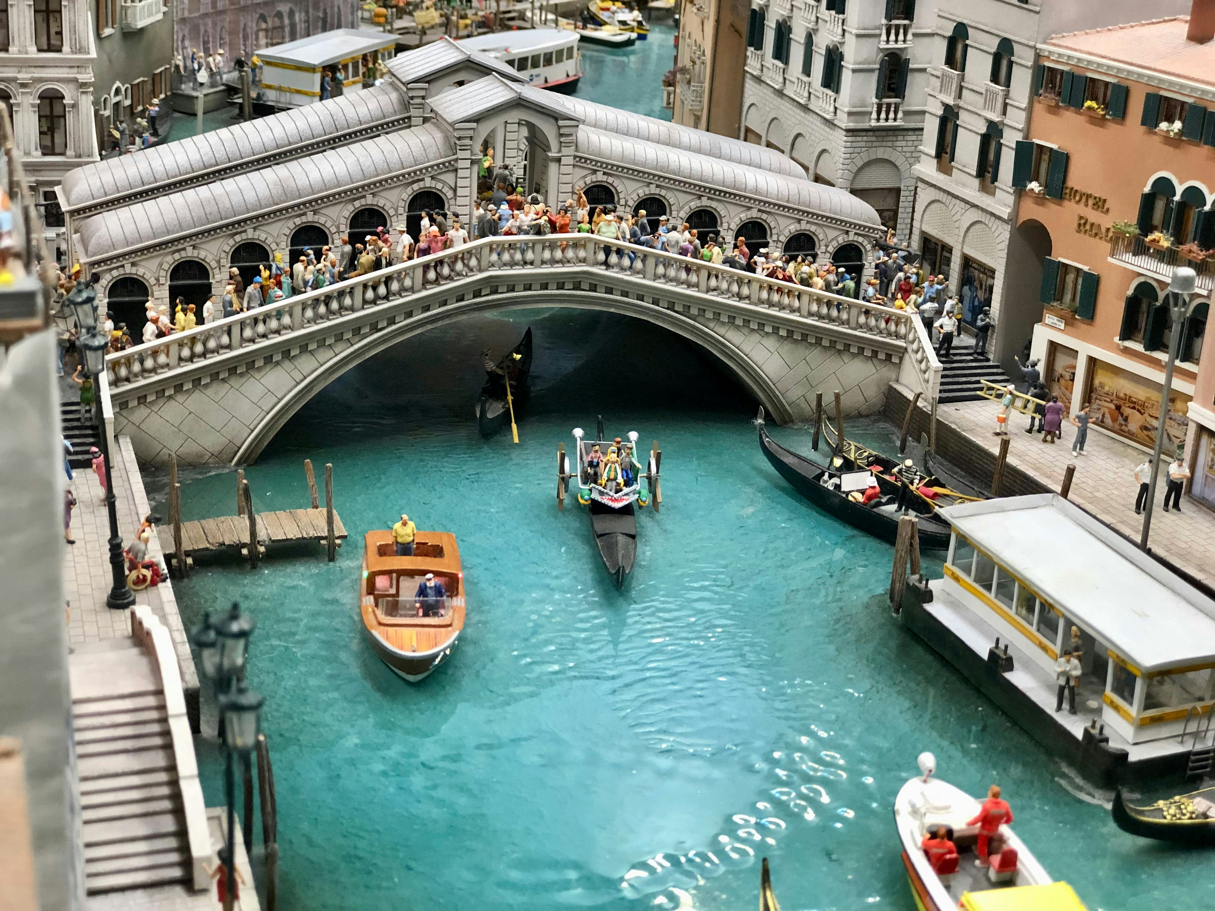 a canal filled with lots of boats next to a bridge