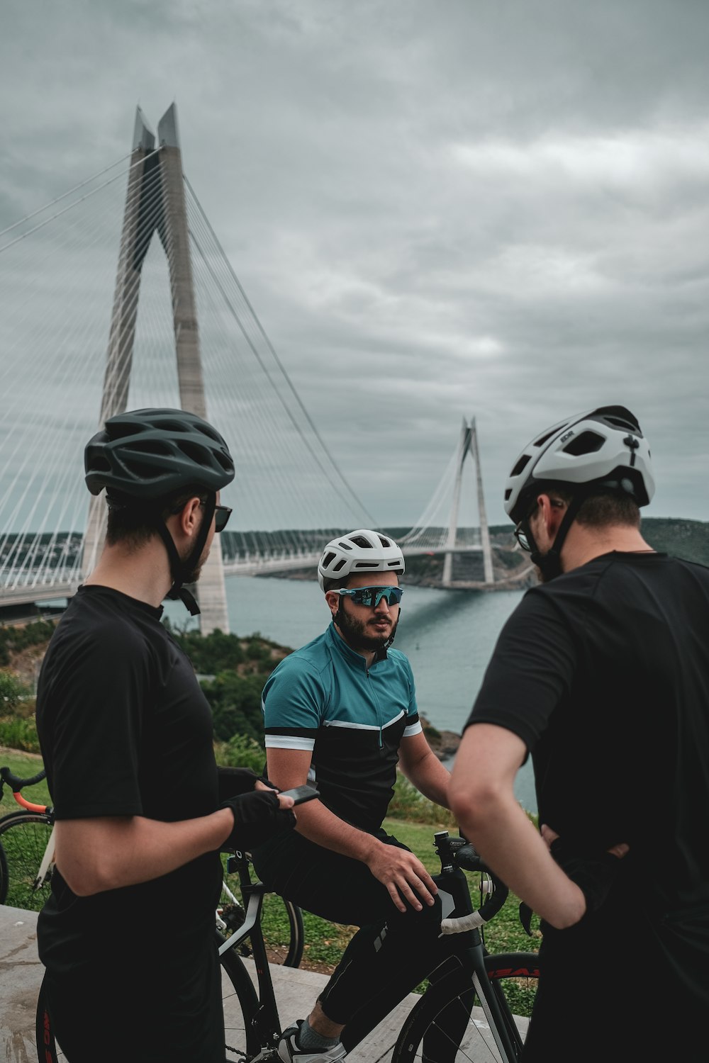 a group of men standing next to each other near a bridge