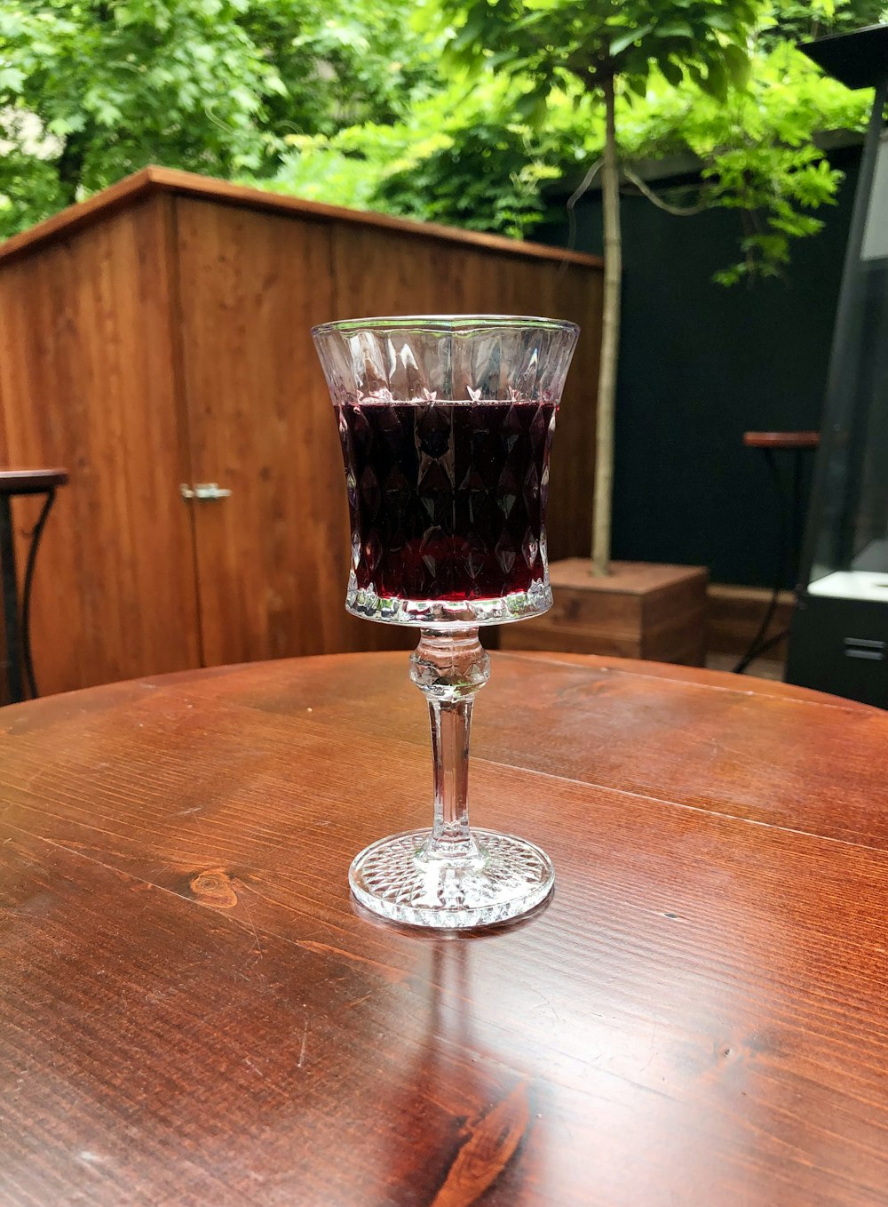 a glass of wine sitting on top of a wooden table