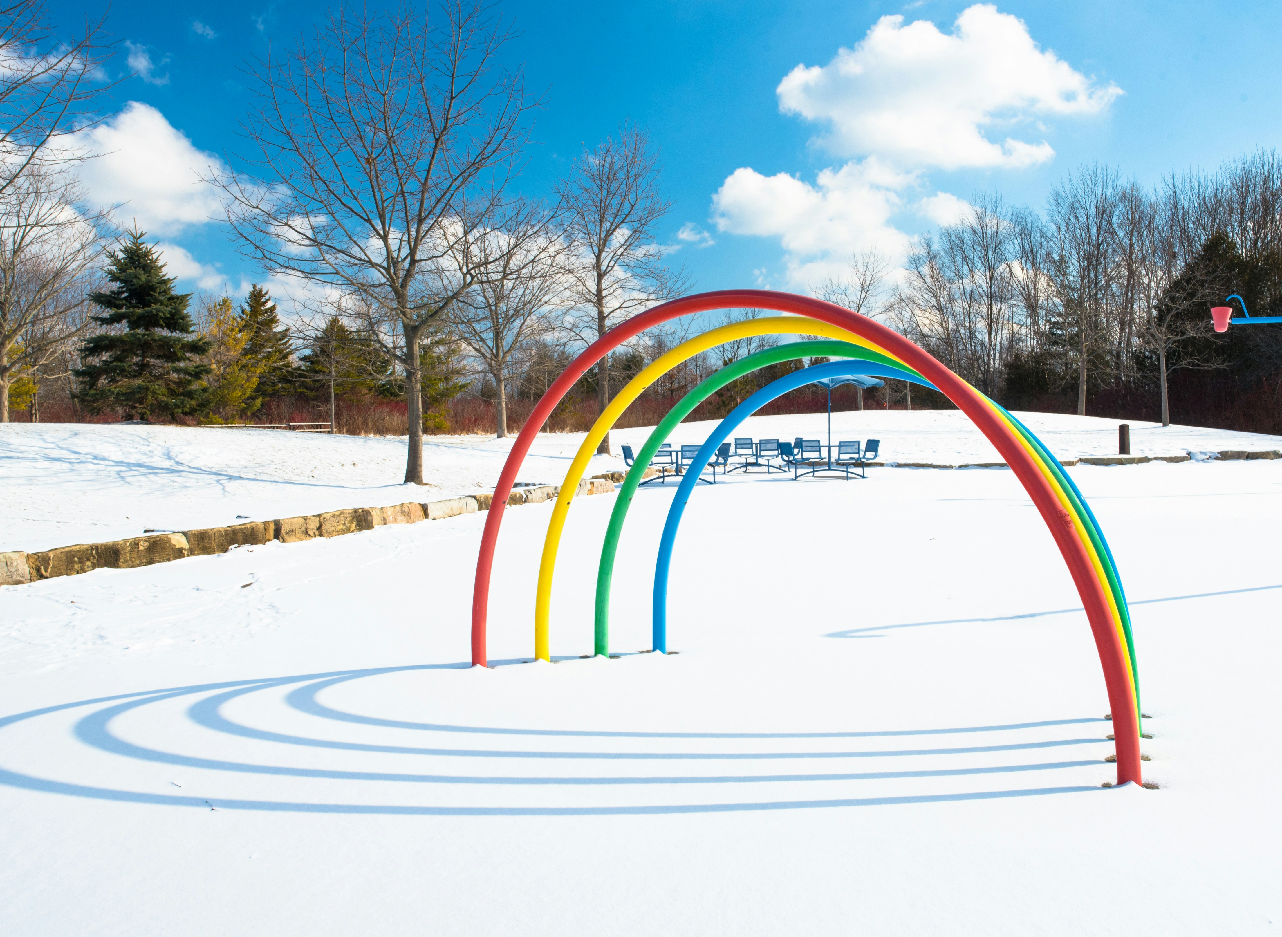 a rainbow arch in the middle of a snow covered field