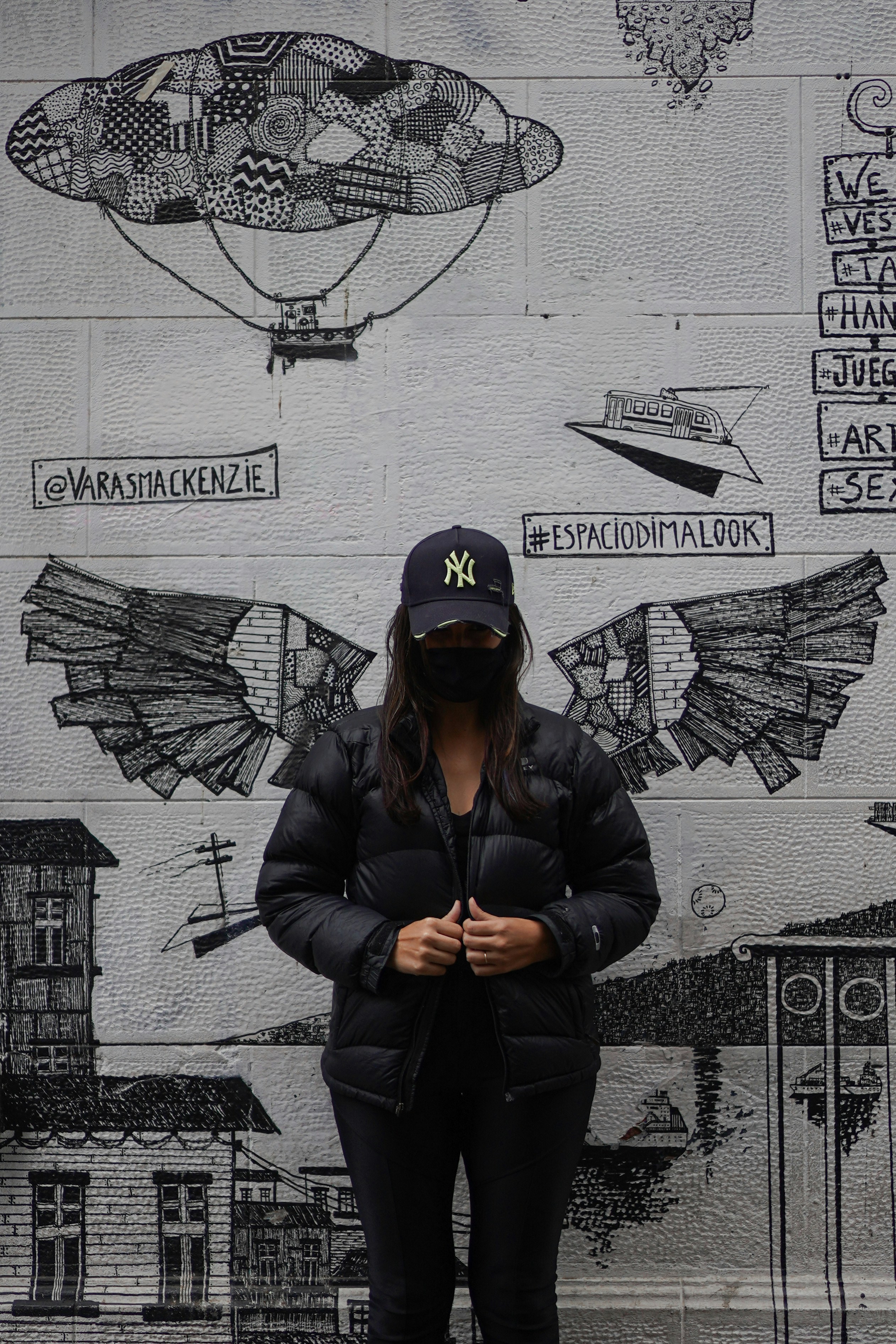 A woman standing in front of a wall covered in graffiti photo – Free ...
