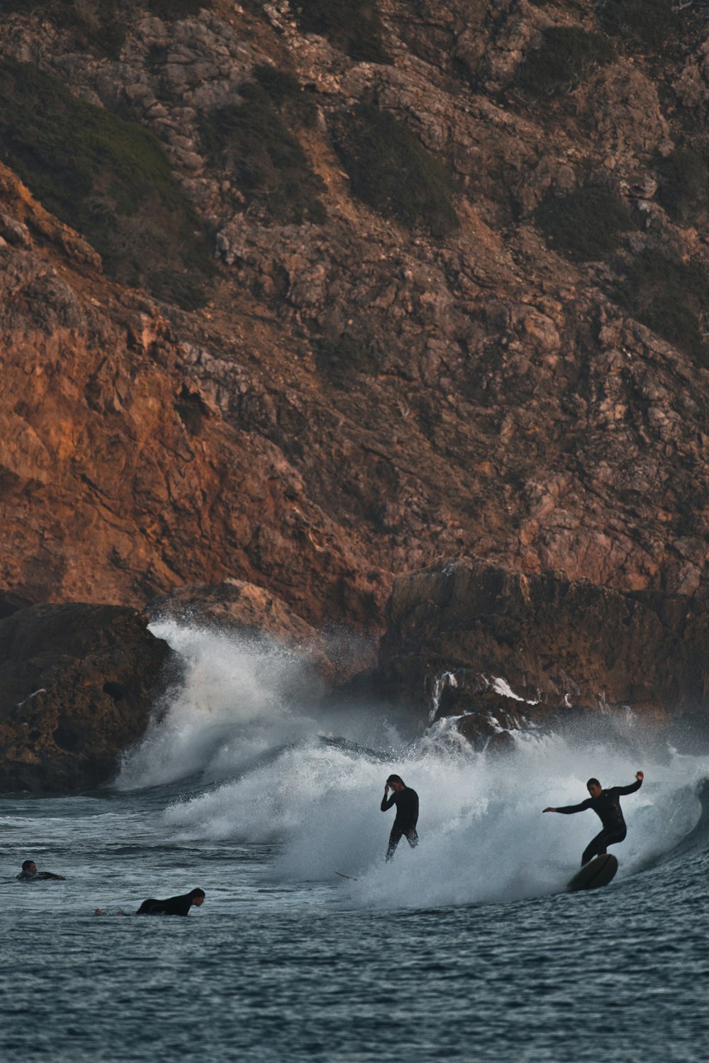 three surfers are riding a wave in the ocean