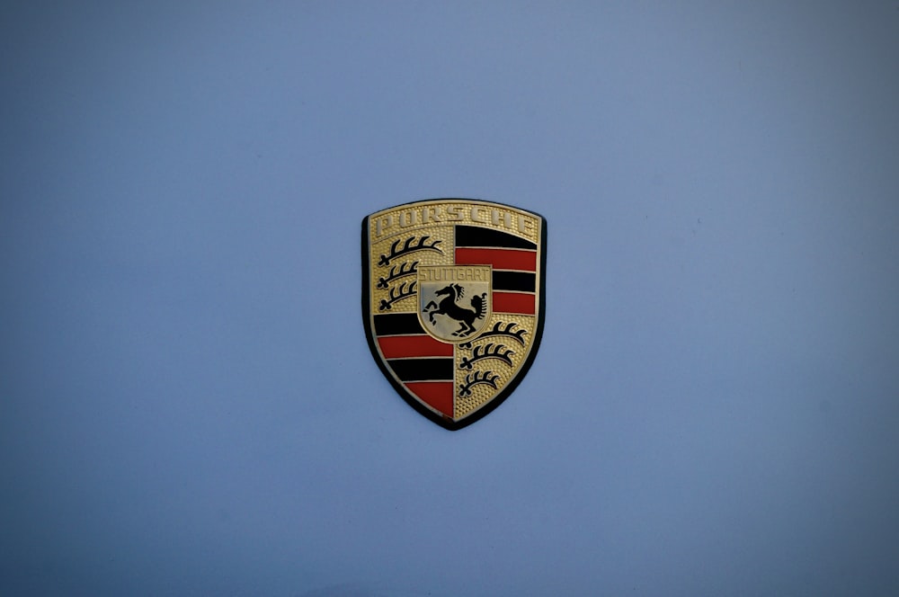 Un primer plano de un emblema de Porsche sobre un fondo azul
