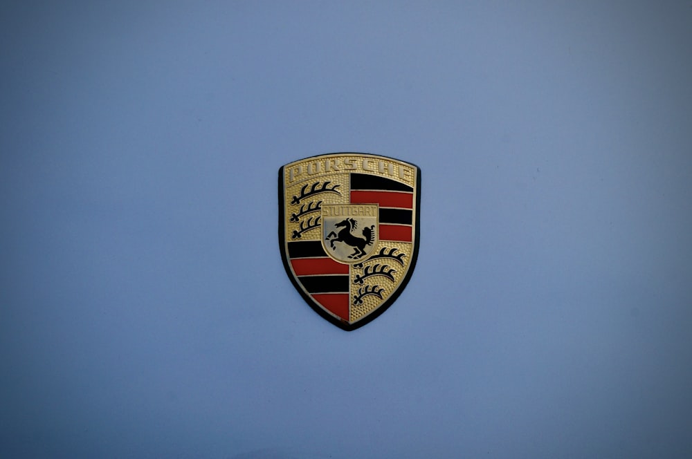 Un primo piano di un emblema Porsche su sfondo blu