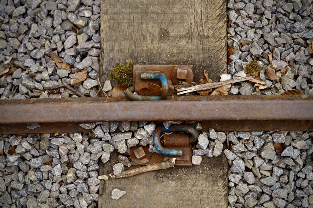 a rusted metal pipe laying on top of a pile of rocks