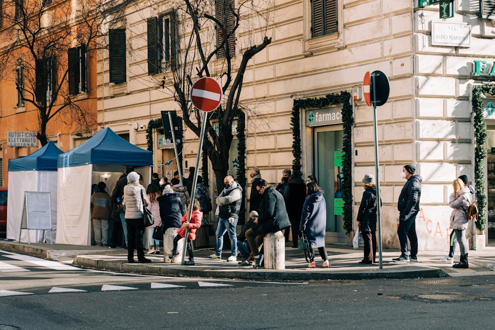 a group of people standing on the side of a street