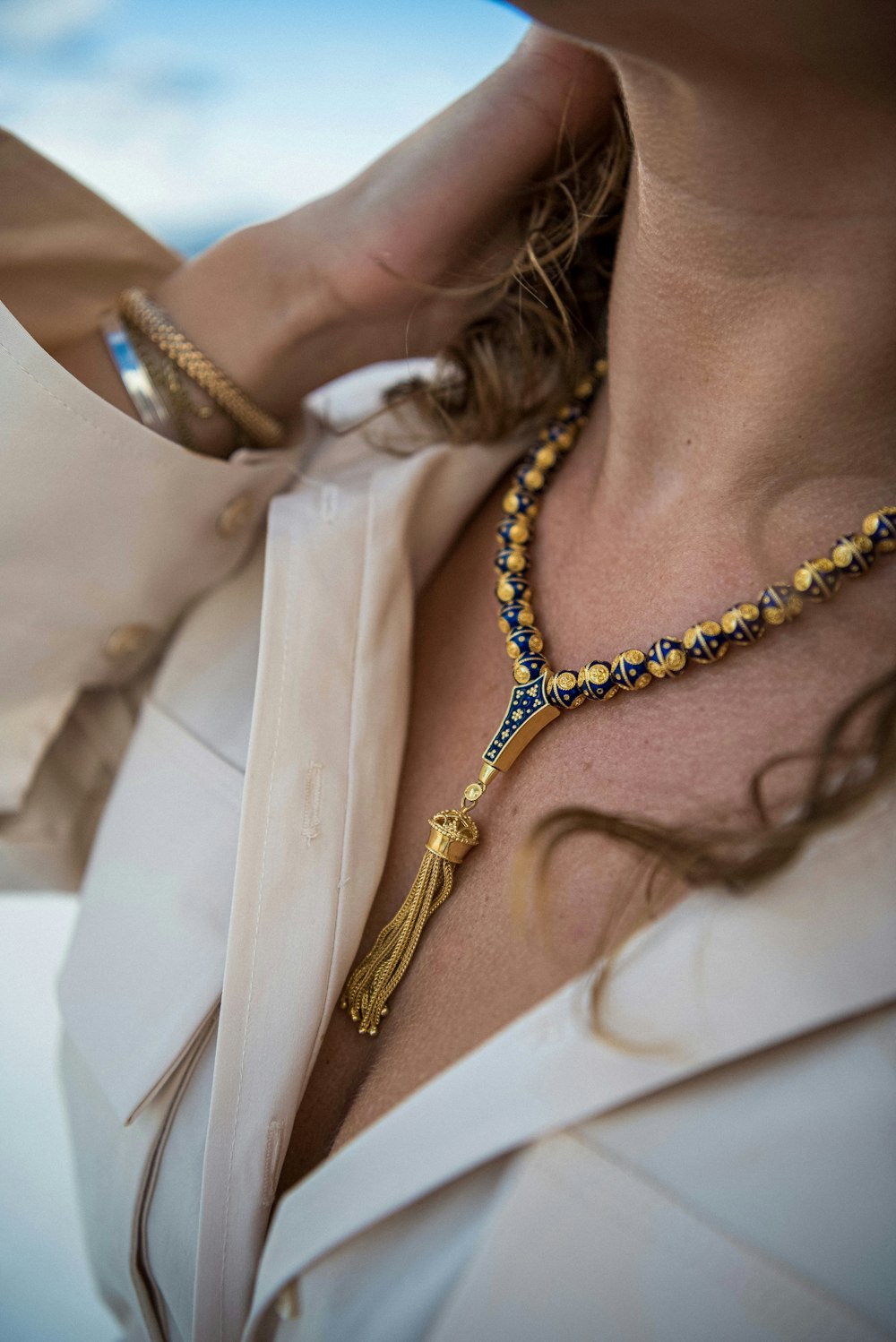 a woman wearing a necklace with a tassel