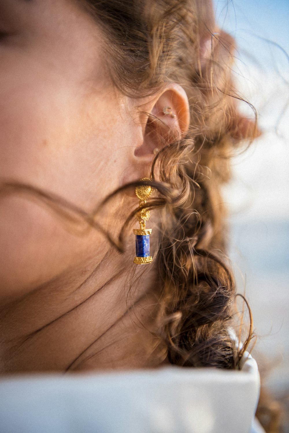 a close up of a person wearing a pair of earrings