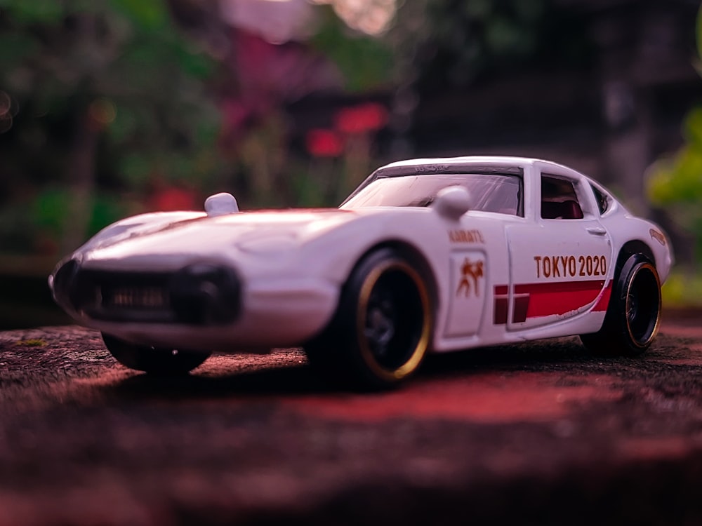 a white toy car sitting on top of a road