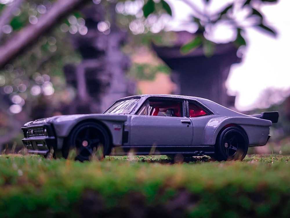 a toy car sitting on top of a lush green field