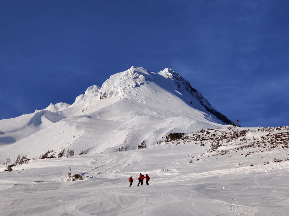 a group of people walking across a snow covered slope