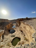 the sun is shining over a small pool of water