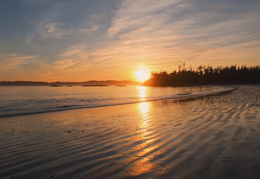Moody atmospheric evening light at a Tofino beach as the sun sets over the grey Pacific waters
