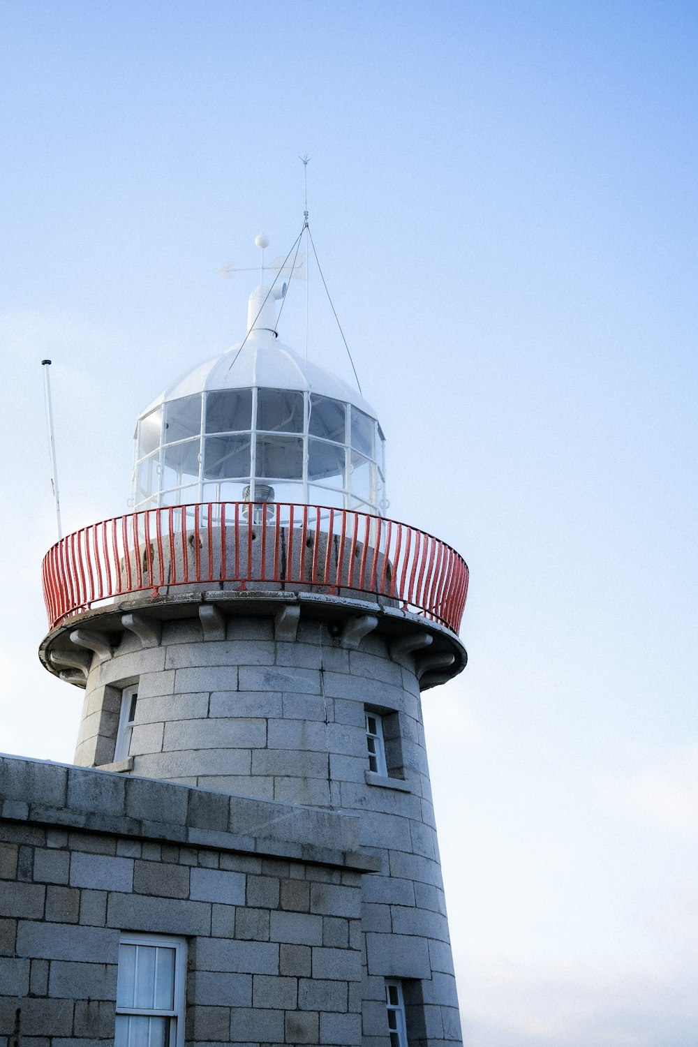 a red and white tower with a red balcony