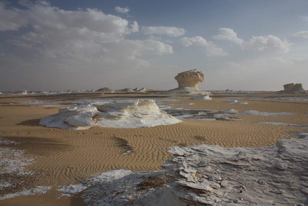 a desert landscape with a rock formation in the distance