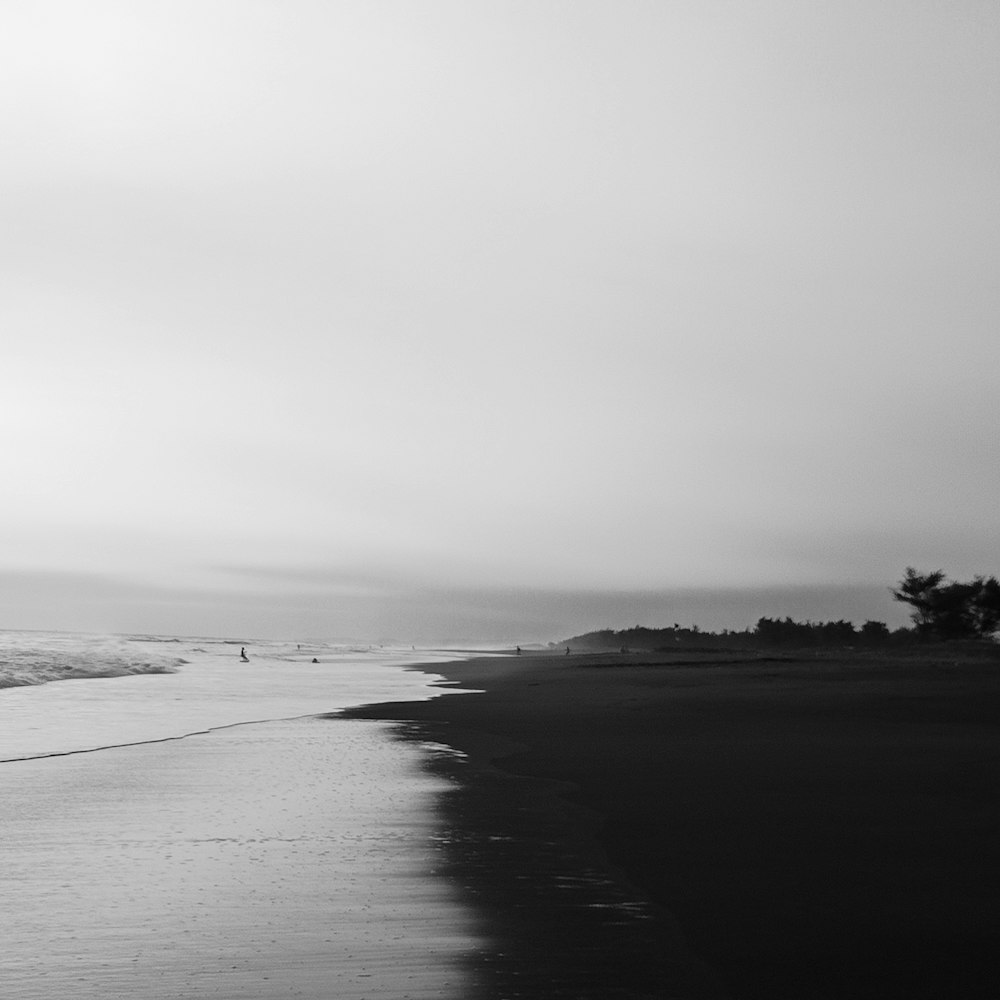 Une photo en noir et blanc d’une plage