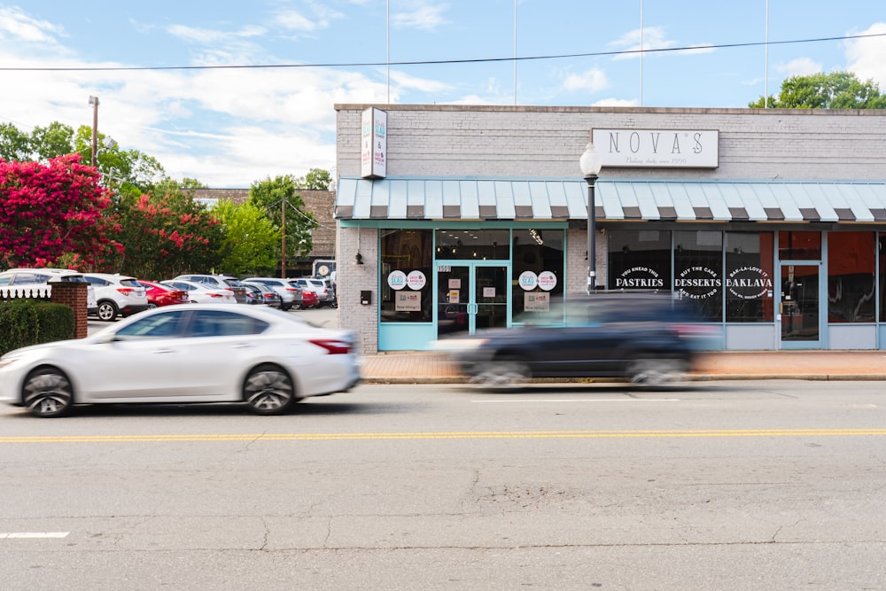 a car driving down a street in front of a store