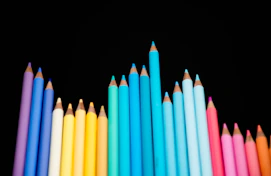 a row of colored pencils sitting next to each other