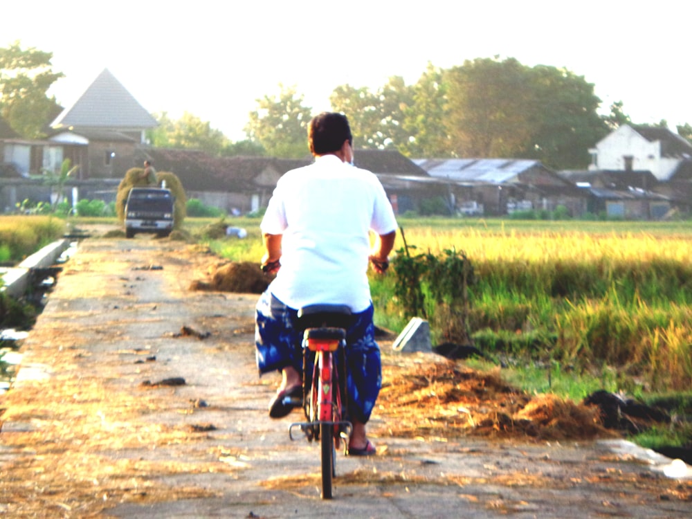 a man riding a bike down a dirt road