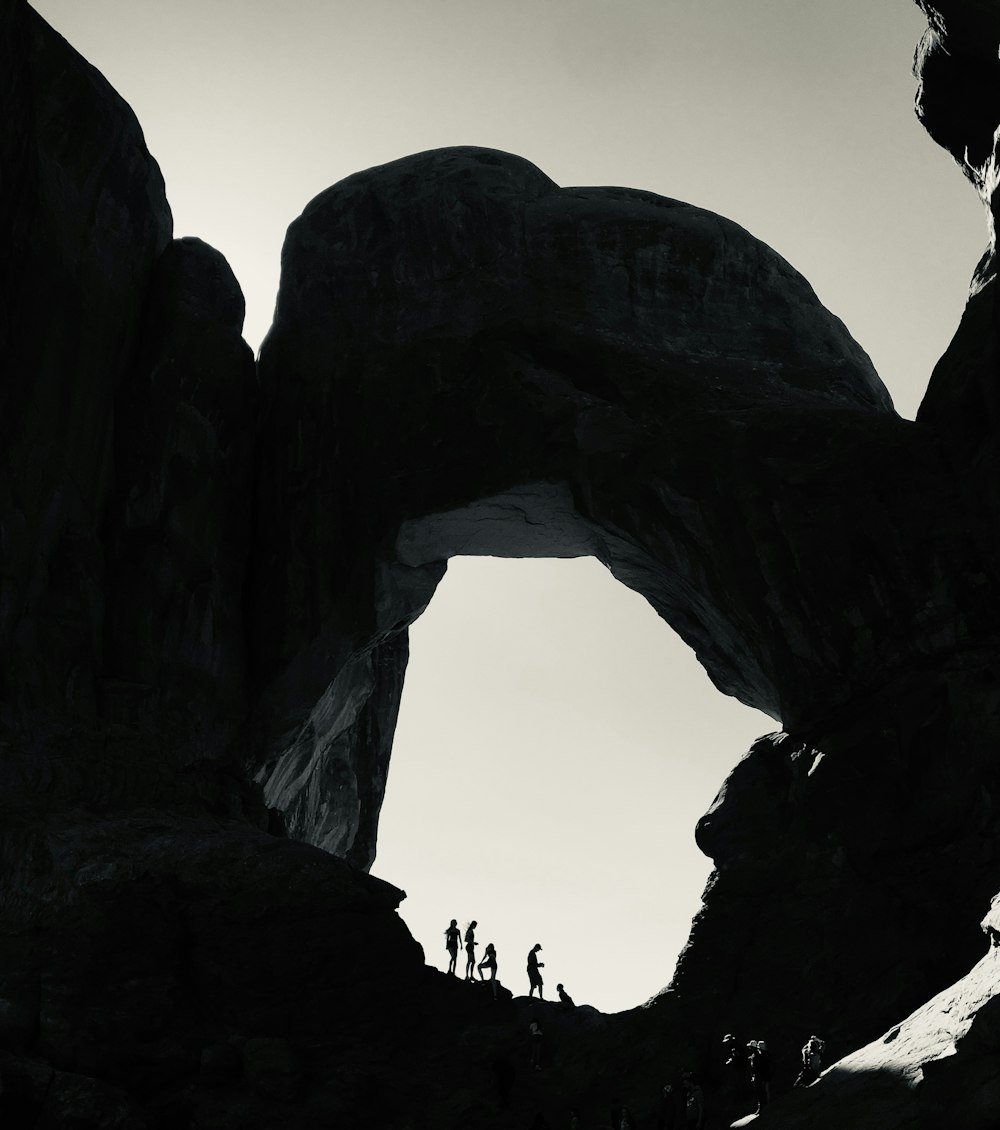 a group of people standing on top of a large rock formation