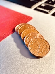 a pile of coins sitting on top of a laptop computer