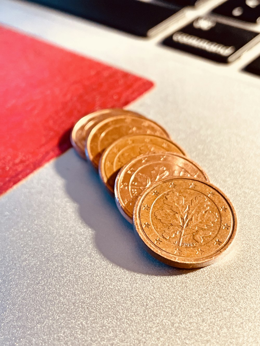 a pile of coins sitting on top of a laptop computer