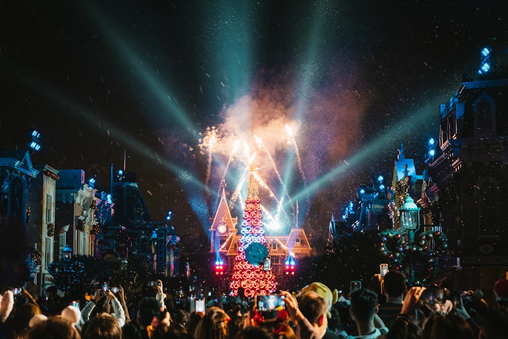 a crowd of people standing around a christmas tree