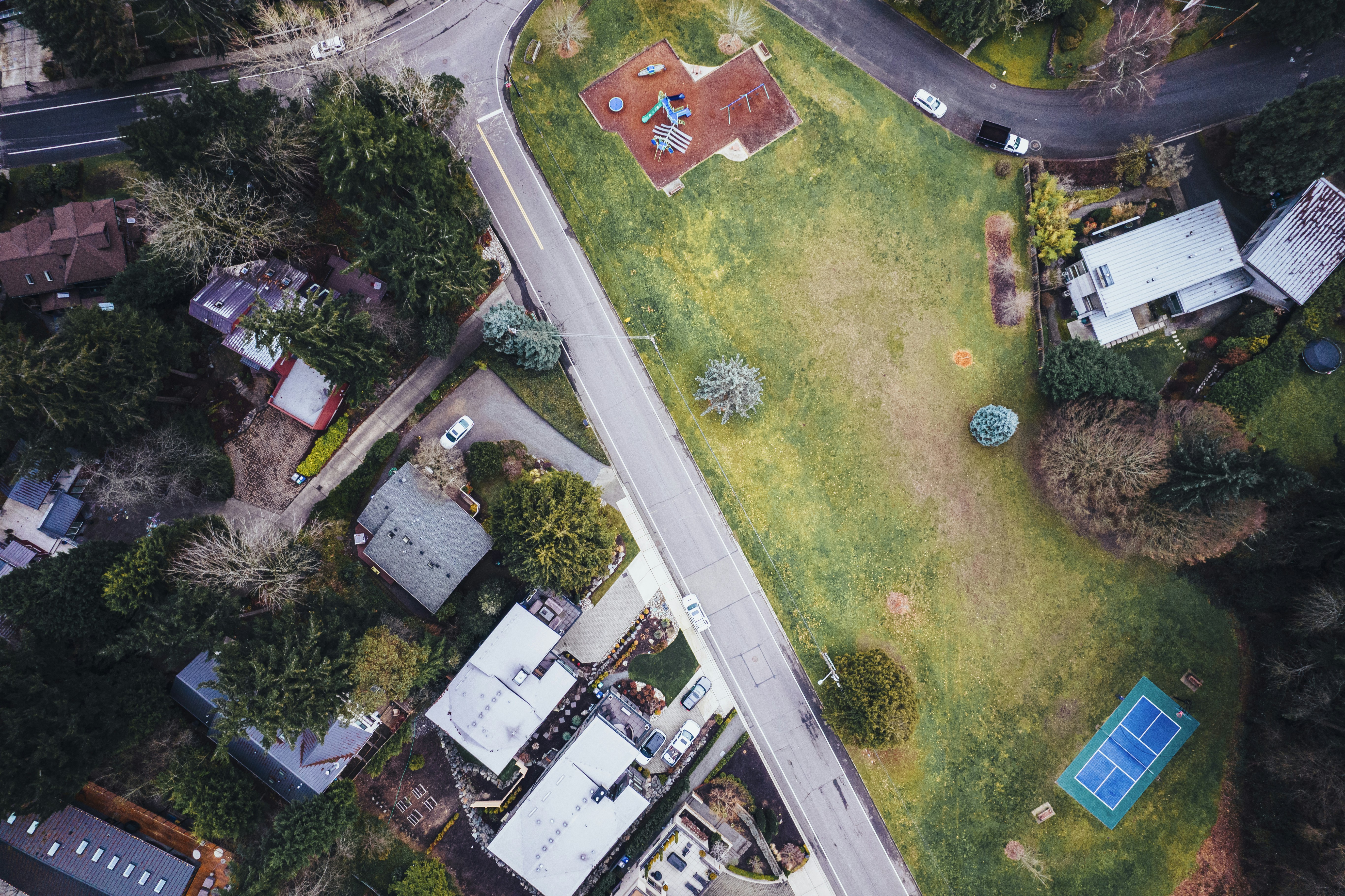 An aerial view of a residential area with a tennis court photo Free