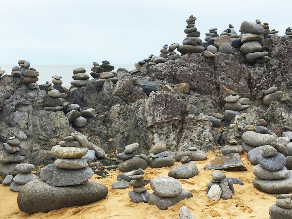 a pile of rocks sitting on top of a sandy beach