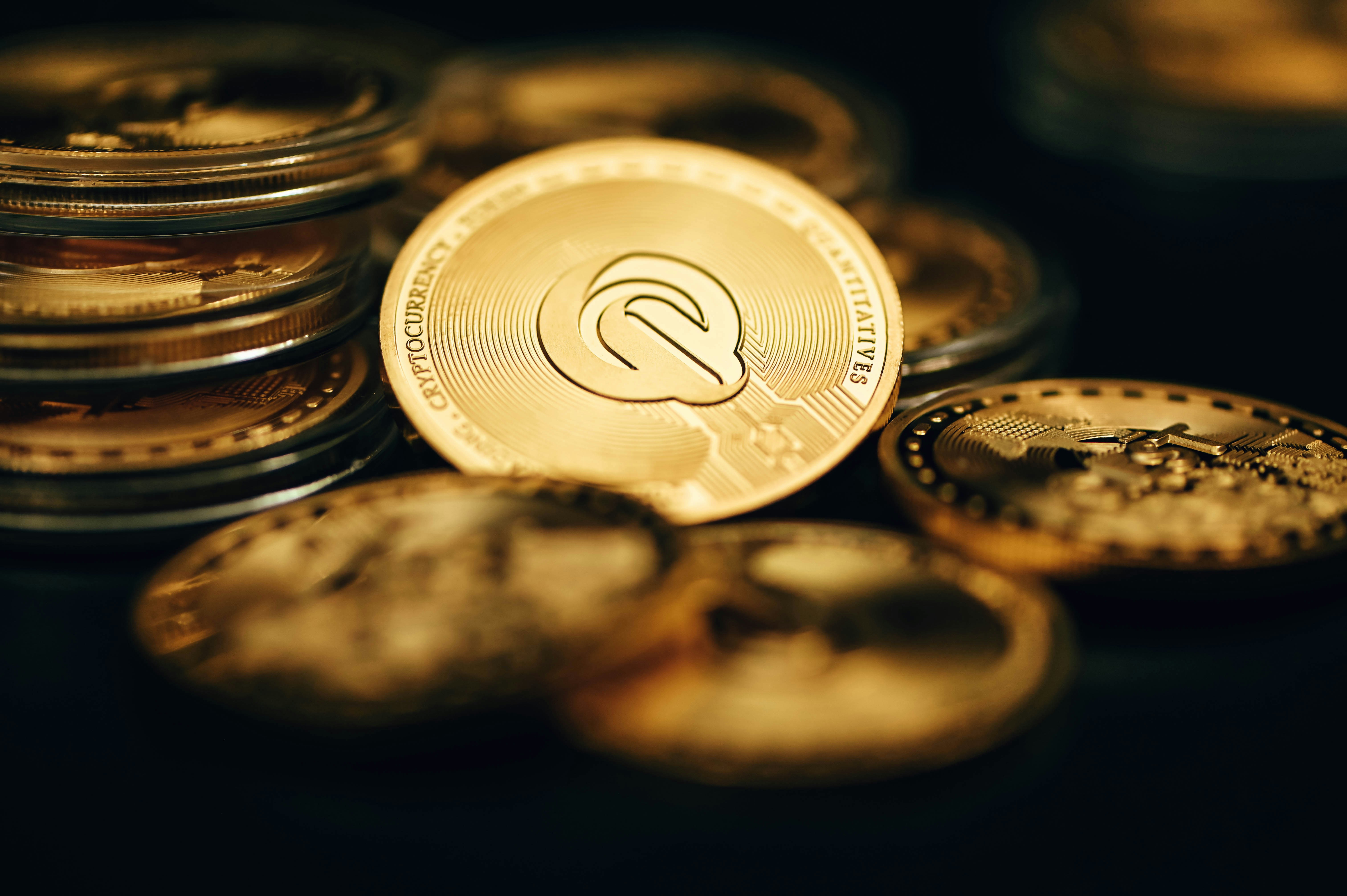 A pile of QEST coins are together in the dark