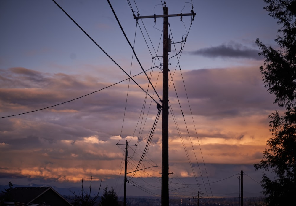 a telephone pole in the distance with a sunset in the background