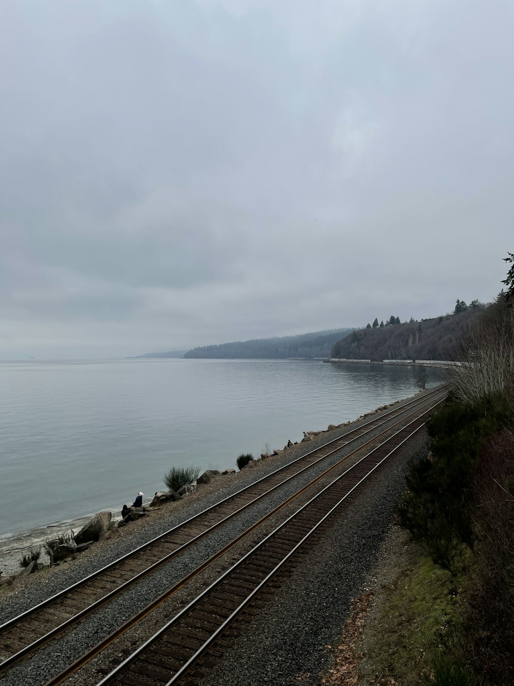 a train track next to a body of water