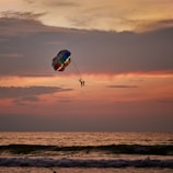 a person is parasailing in the ocean at sunset