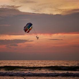 a person is parasailing in the ocean at sunset