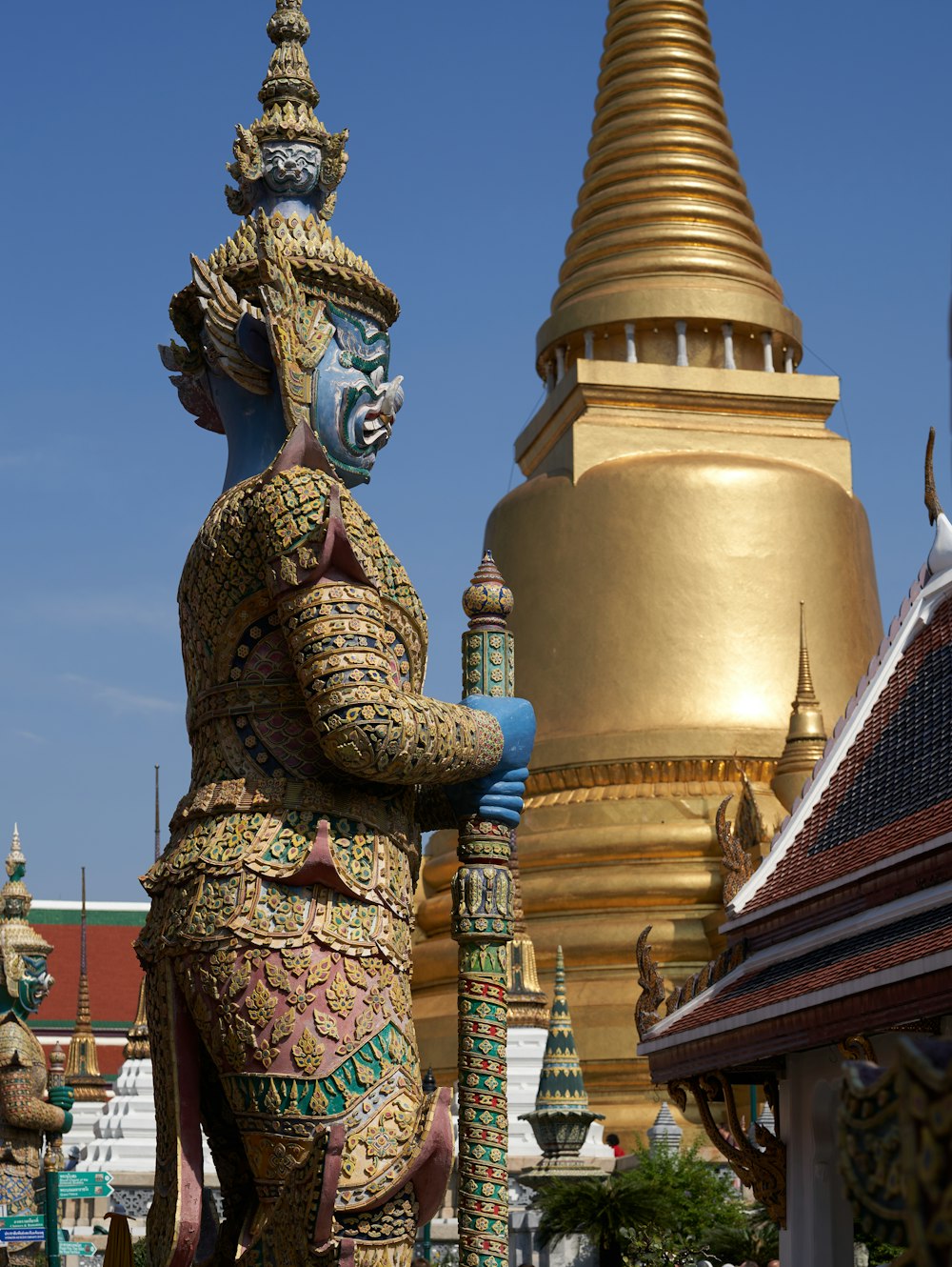 a statue of a woman holding a vase in front of a gold spire