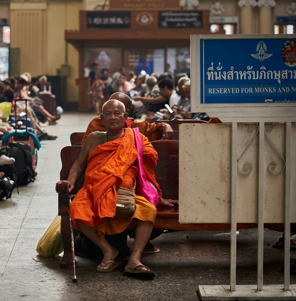 a man sitting on a bench with a stick in his hand