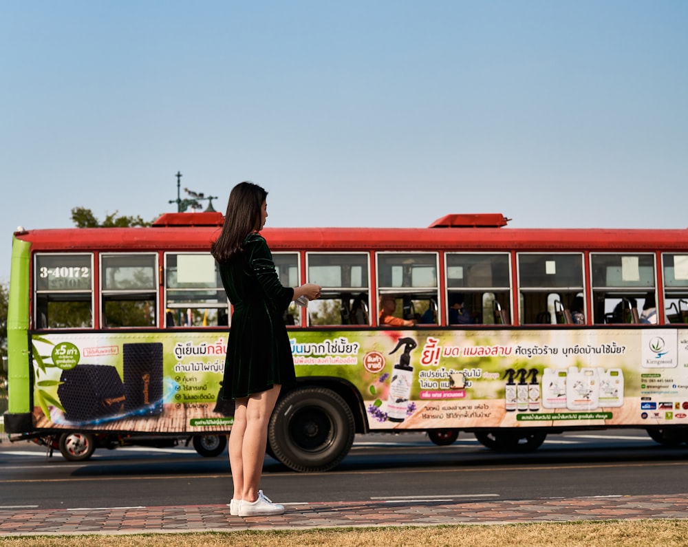 a woman standing in front of a bus