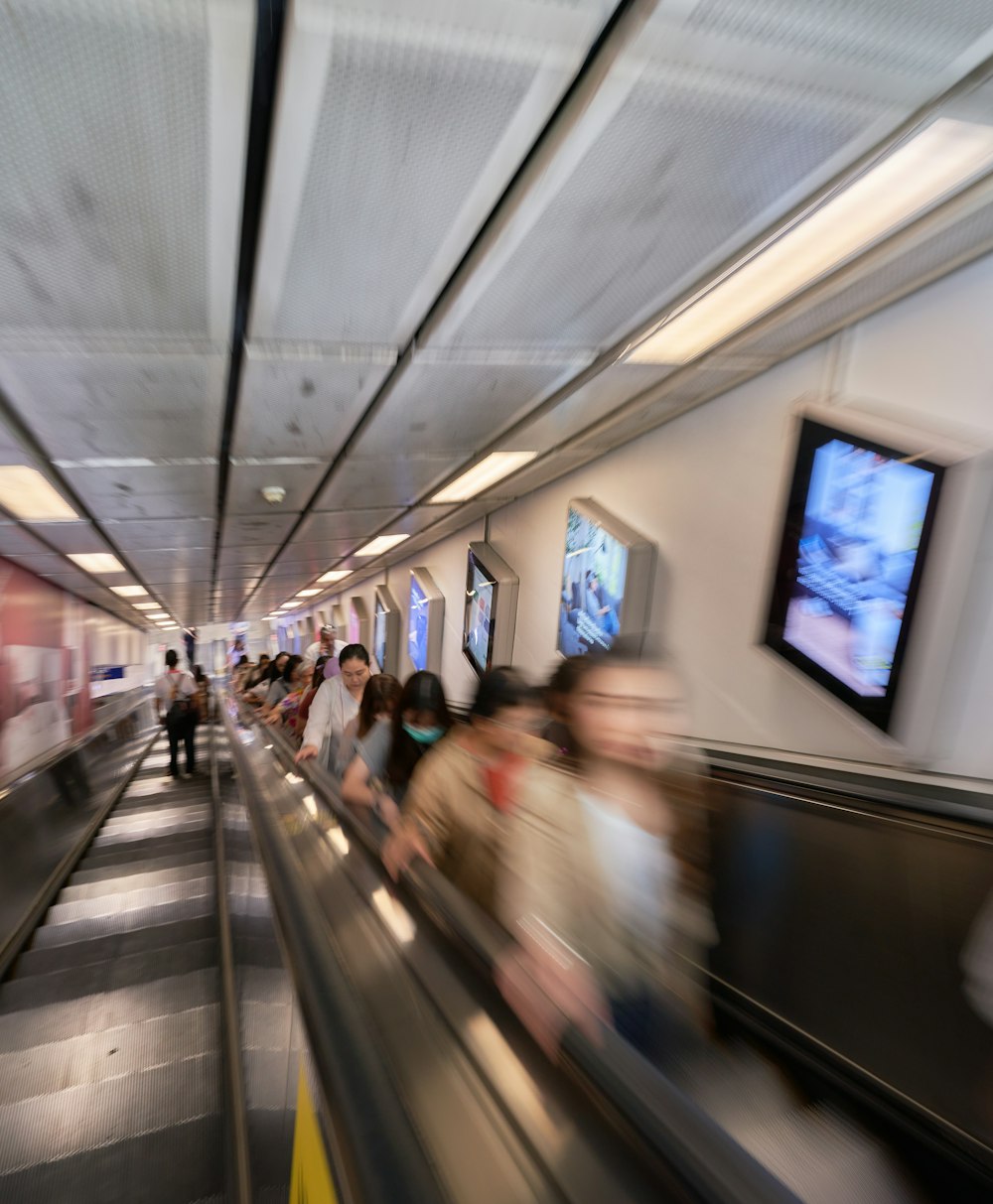 a blurry photo of people riding an escalator