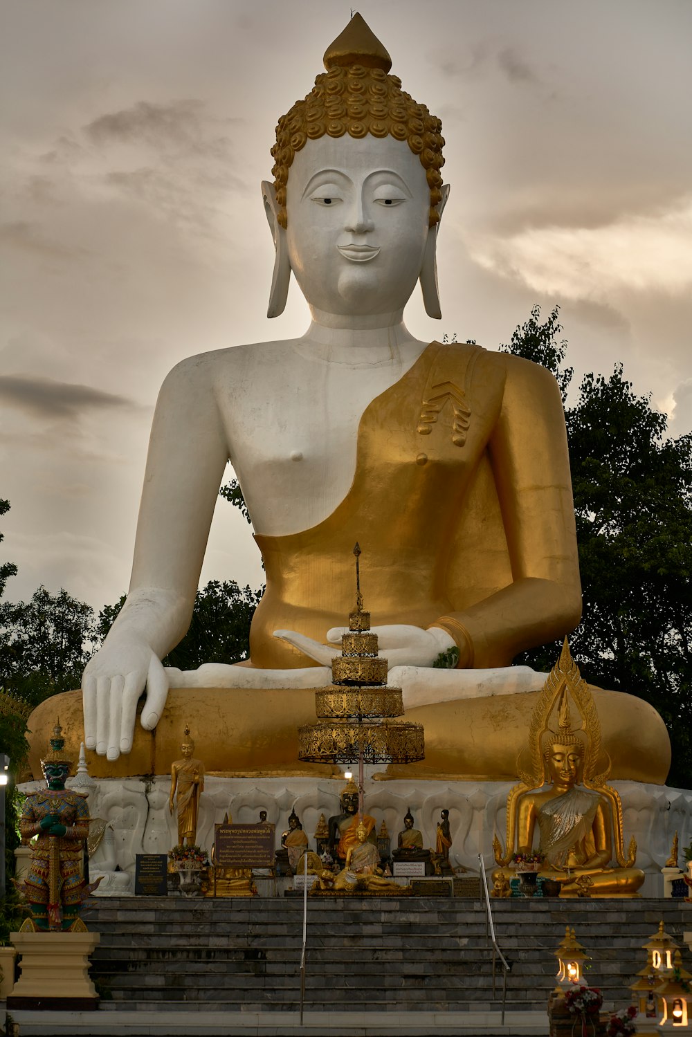 Una gran estatua dorada de Buda sentada en un parque