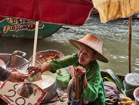 a woman in a straw hat is serving food to another woman